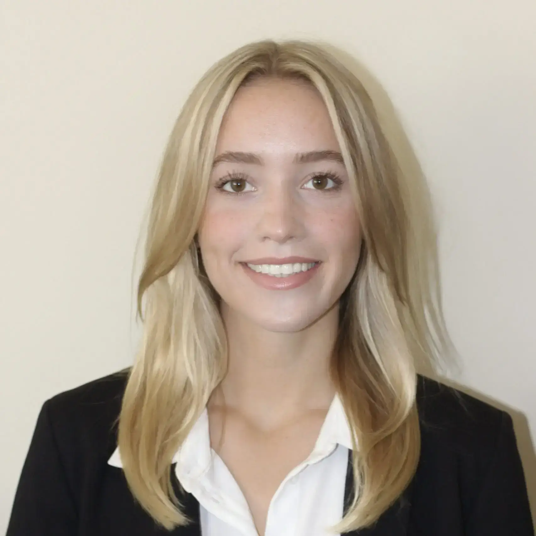 Headshot of Kara Reed, employee at SmartSpace, dressed in white button up and black blazer, smiling at camera.