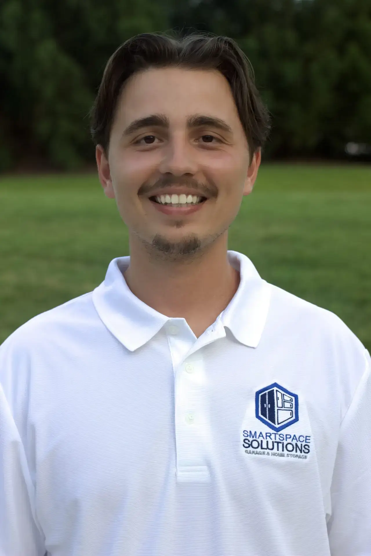 Headshot of Levi Reed, SmartSpace Employee, smiling at camera with white SmartSpace shirt.