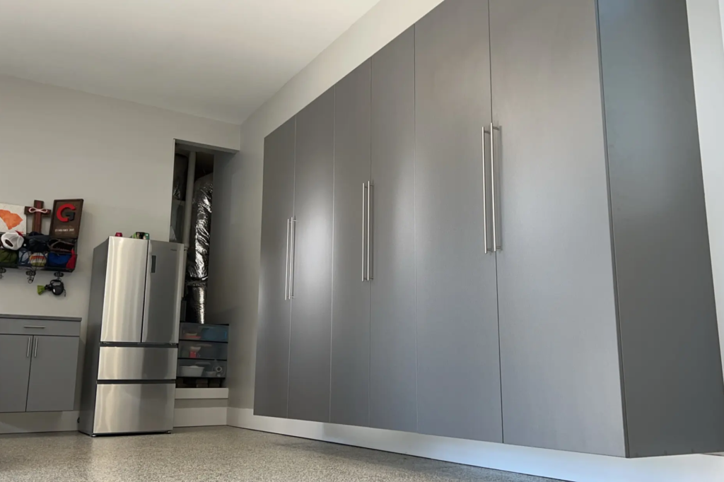 Garage with custom storage cabinets and durable polyaspartic flooring for a sleek, organized space